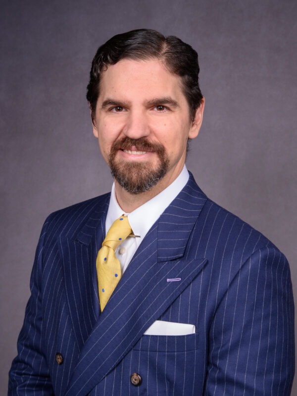 Headshot of agent Donald T. Shaver in a blue suit with a yellow tie