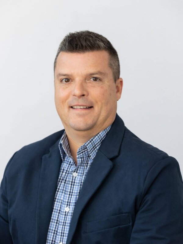 agent Jeff Bommarito's headshot in a navy blue suit with a blue plaid button up shirt