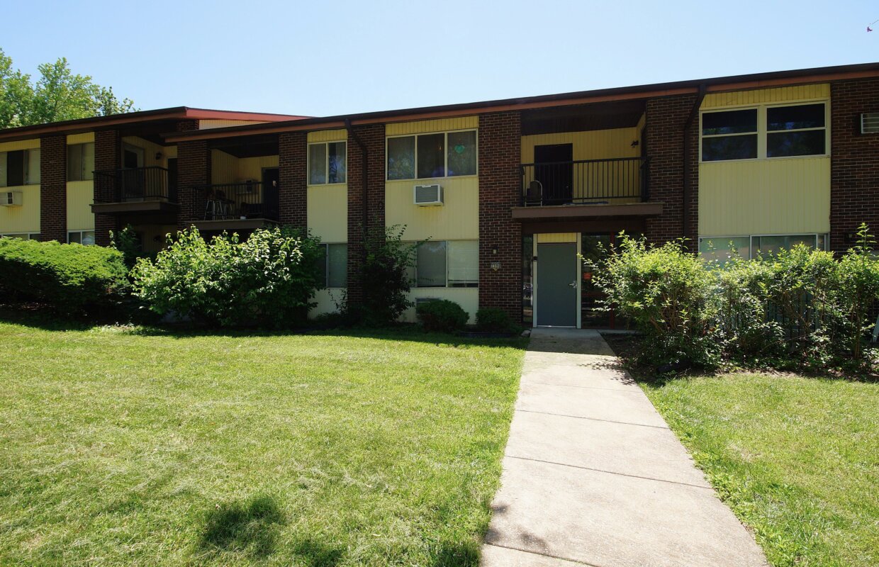 Hazelcrest condos exterior of one of the buildings with a sidewalk to the units and yard area