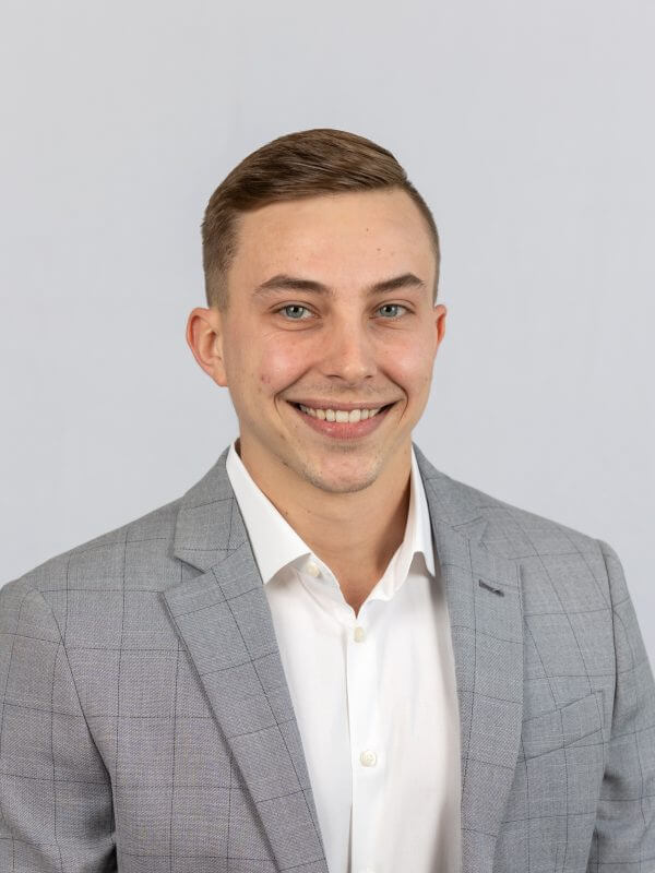 Agent Kyle Blake headshot in a grey suit and white button up shirt