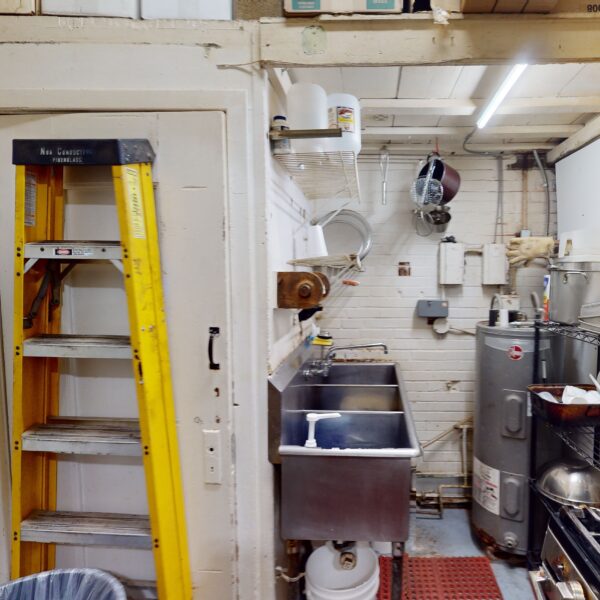 1450000 | 2201 Edwards St., St. Louis, MO 631102201 Edwards Deli Kitchen Space with ladder by left doorway and various cooking equipment to the right