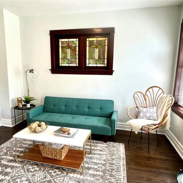 695000 | 5537 Holly Hills Ave., St. Louis, MO 631095537 Holly Hills living room area from the entry doorway showing a teal couch and stained glass window