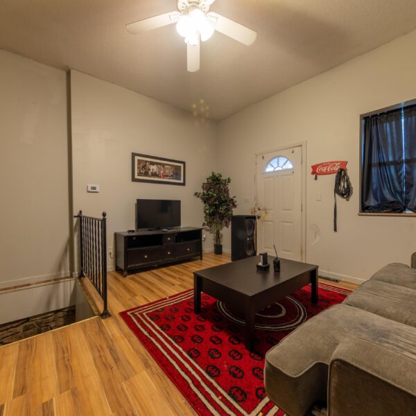 196000 | 3741 Salena St., St. Louis, MO 631183741 Salena living room with a red rug on light colored hardwood floors and stairs leading down on the left