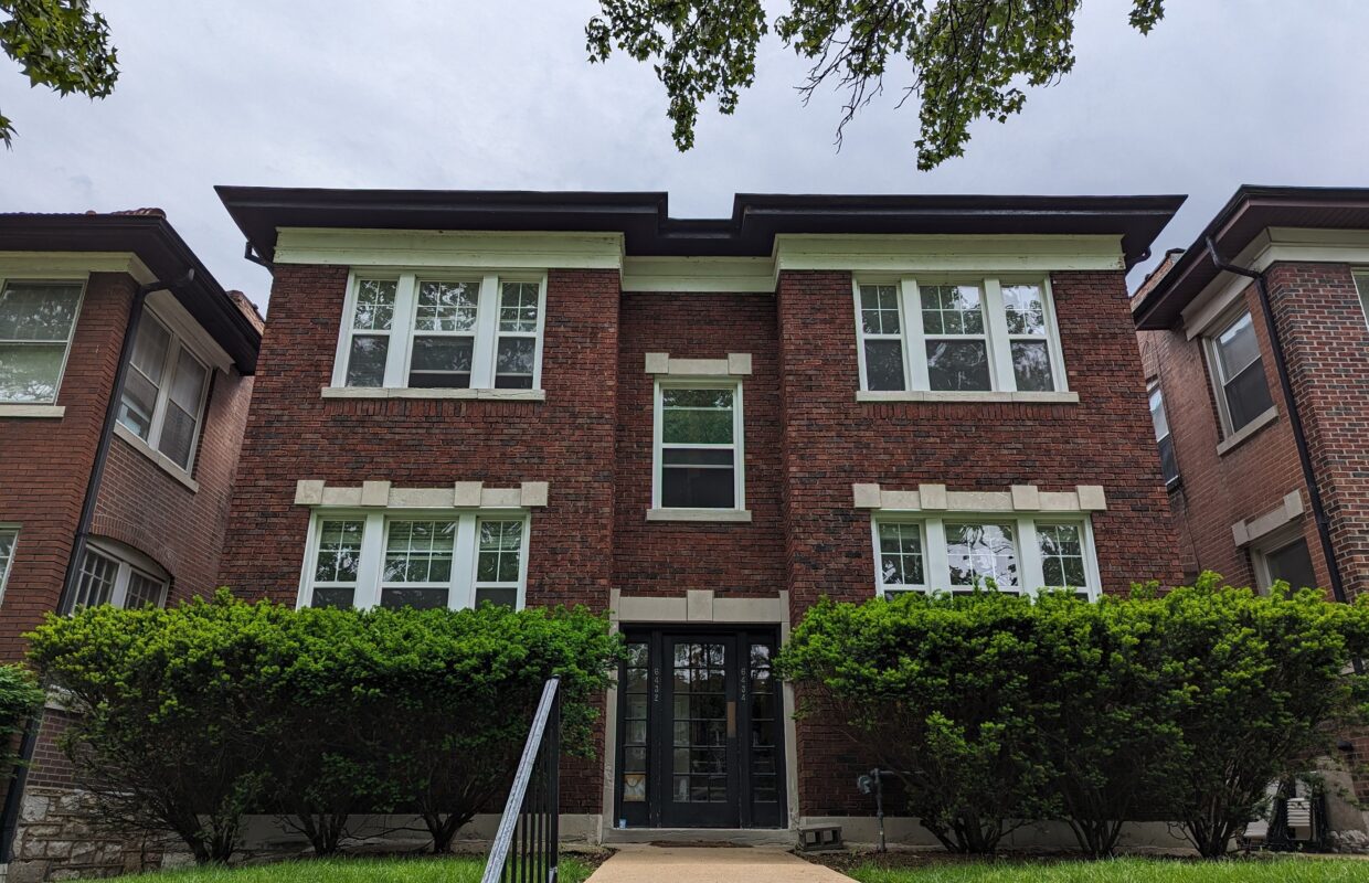 6432 Alamo front of brick two story building with bushes lining the front building with a sidewalk leading up to the entry