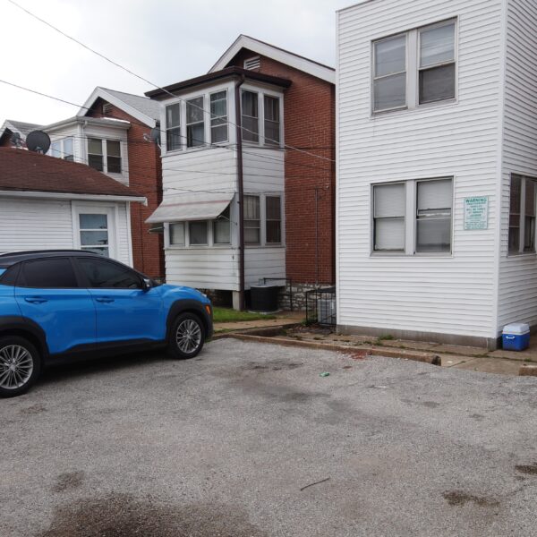 335000 | 6134 S. Grand Blvd., St. Louis, MO 631116134 S Grand Exterior parking pad with a blue car parked and the back of various buildings behind