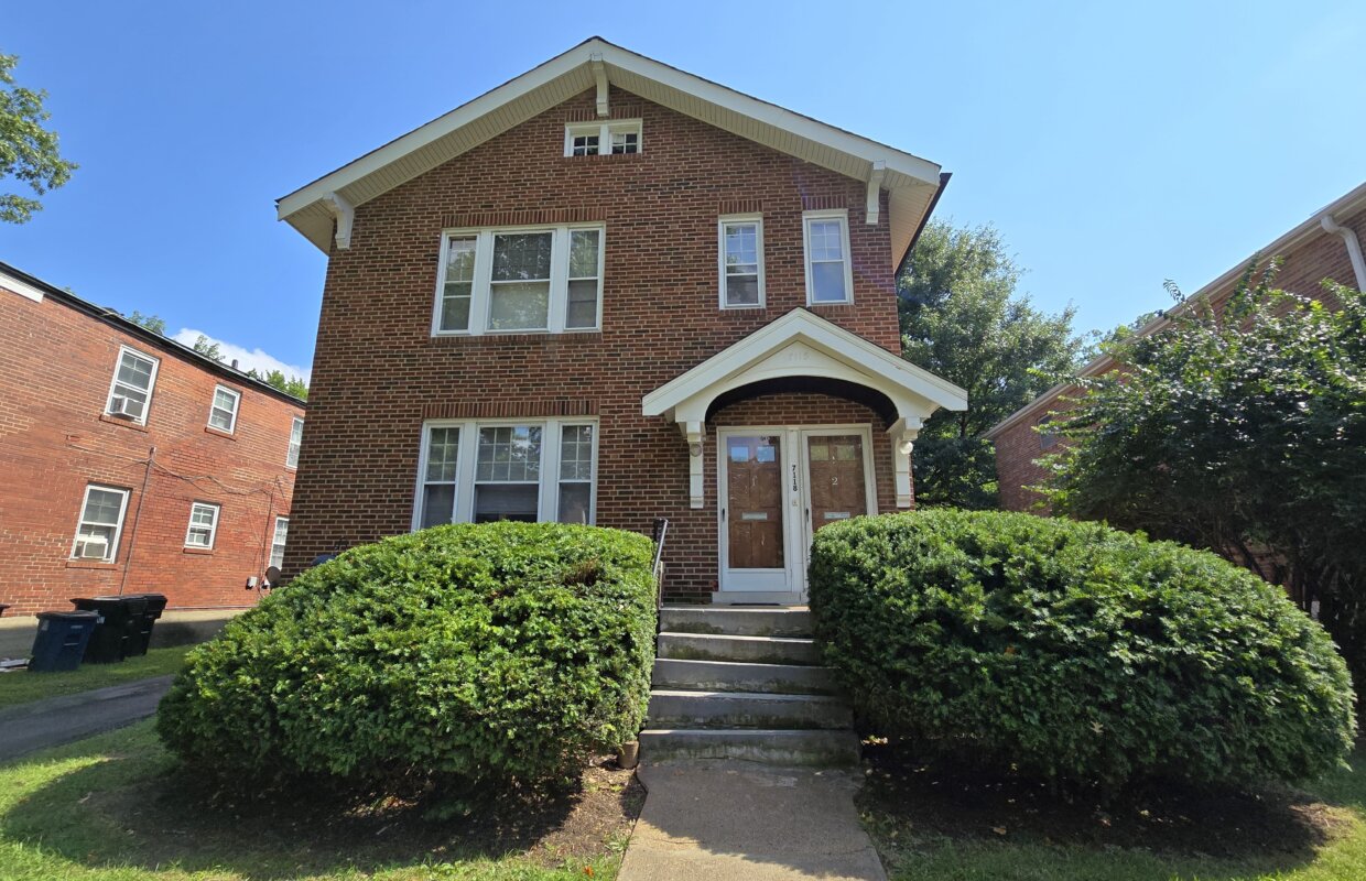 7118 Amherst front exterior with two bushes lining the sidewalk up to the front doors