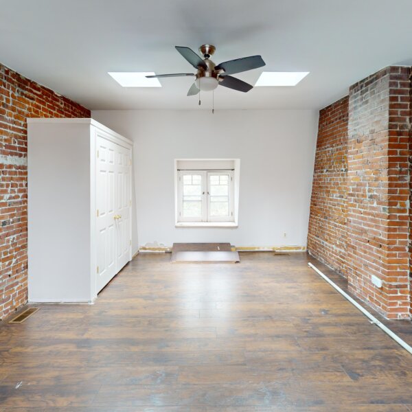 130000 | 2210A Wyoming St., St. Louis, MO 631182210A Wyoming large 2nd floor bedroom from the middle of the room with a built in closet, a small window, and two exposed brick walls.