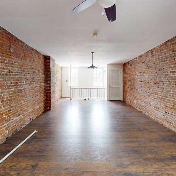 130000 | 2210A Wyoming St., St. Louis, MO 631182210A Wyoming large 2nd floor bedroom with exposed brick lining the walls toward the stairs, two windows, and a closet