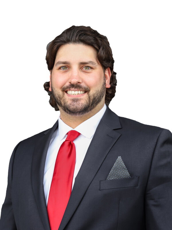 Agent Matt Guignon's headshot in a black suit with a red tie