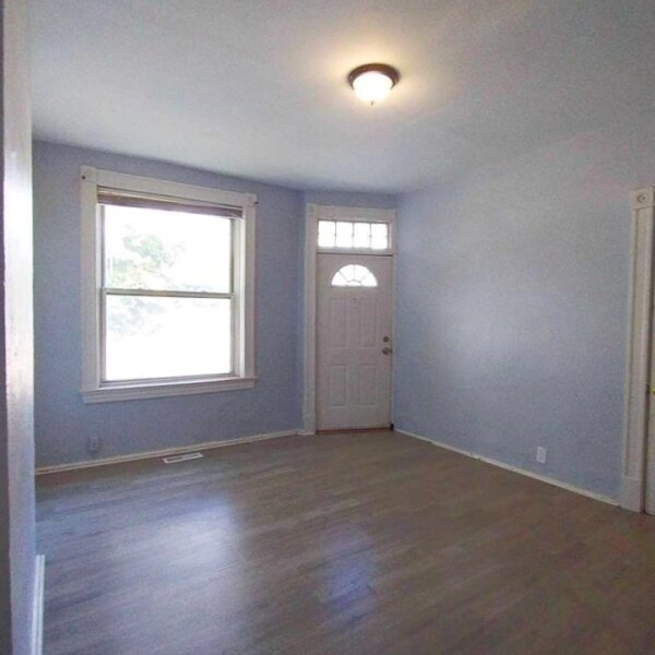 205000 | 3306 Louisiana Ave, St. Louis, MO 631183306 Louisiana living room entry showing the unit front door, light blue painted walls, and hardwood floors